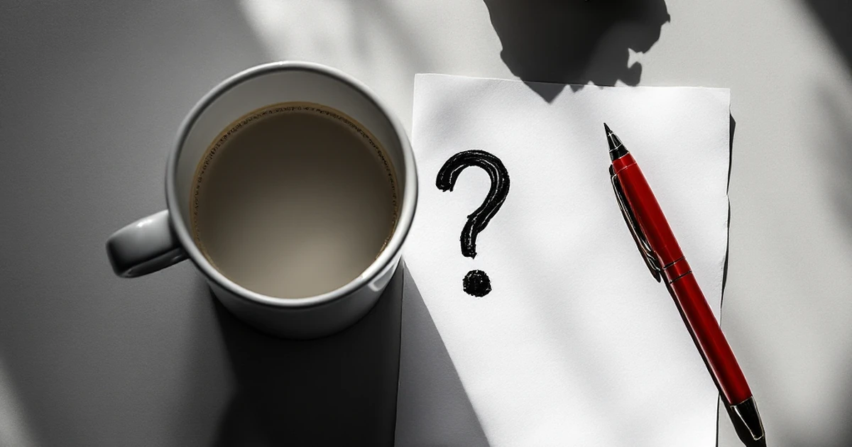 Coffee mug with question mark next to crumpled paper and red pen for troubleshooting